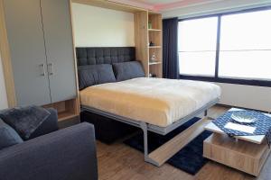 ein kleines Schlafzimmer mit einem Bett und einer Couch in der Unterkunft Haus "Jan am Strand" Appartement JAN002 in Döse