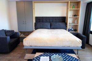 ein Schlafzimmer mit großem Bett und Couch in der Unterkunft Haus "Jan am Strand" Appartement JAN002 in Döse