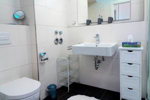 ein weißes Badezimmer mit Waschbecken und Toilette in der Unterkunft Haus "Jan am Strand" Appartement JAN002 in Döse + 10 Fotos