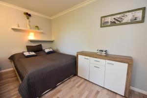 a small bedroom with a bed and a cabinet at "Im Herzen von Döse" Appartement IHvD1 in Döse