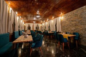 un restaurante con mesas largas y sillas azules en Hotel Cumpatu, en Sinaia