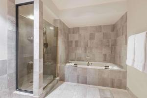 a bathroom with a tub, shower, and sink at The Antlers, A Wyndham Hotel in Colorado Springs