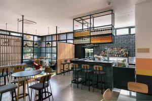a bar in a restaurant with tables and chairs at WQ Wellington Quarter Hotel in Wellington