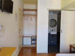 a room with a bathroom with a sink and a mirror at Anastasia Hotel in Symi