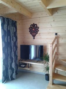 a log cabin with a tv and a staircase at DOMEK NA WIERCHU in Kluszkowce