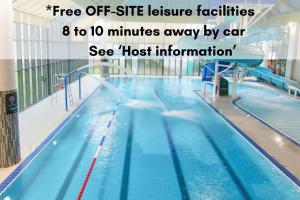 ein großes Schwimmbecken mit blauem Wasser in einem Gebäude in der Unterkunft Crylla Valley Cottages - access to pool, gym, spa and more in Saltash