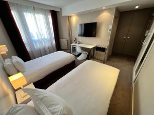 pokój hotelowy z 2 łóżkami i telewizorem w obiekcie Holiday Inn Paris-Auteuil, an IHG Hotel w Paryżu