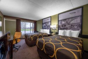 a hotel room with two beds and a desk at Super 8 by Wyndham Perrysburg-Toledo in Perrysburg