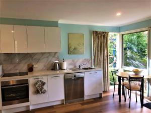 uma cozinha com armários brancos e uma mesa em Countryside Retreat romantic tranquil native wildlife township Hepburn - Daylesford em Hepburn Springs