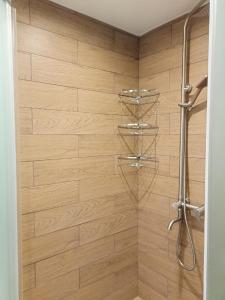 ein Bad mit einer Dusche und einer Holzwand in der Unterkunft Chusovskaya Hotel in Zavod Chusovskoye