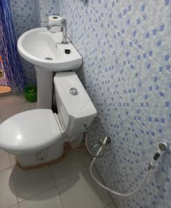 a bathroom with a toilet and a sink at SAM RESIDENCE Jàmm ak Cofeel in Saint-Louis
