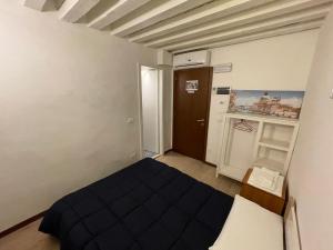 Cette petite chambre comprend un lit et une porte. dans l'établissement Dimora Blu Suite, à Venise