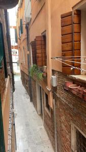 an alley with buildings and plants on the side at Dimora Blu Suite in Venice +46 photos
