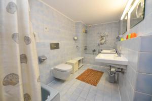 ein blau gefliestes Badezimmer mit Toilette und Waschbecken in der Unterkunft Haus "Jan am Strand" Appartement JAN504 in Döse