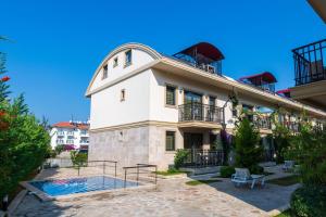 a large white building with a pool in front of it at Yaşam Park Residence - Fethiye Calis Beach in Fethiye