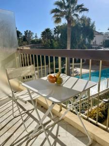 Biały stół na balkonie z misą owoców w obiekcie Seafront one bedroom apartment with a terrasse swimming pool and a parking w mieście Antibes