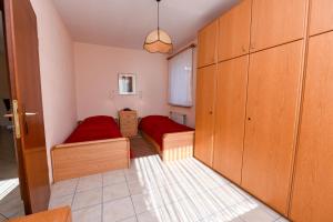 a small room with two beds and wooden cabinets at Haus "Luv und Lee" Appartement LEE01 in Döse +13 photos