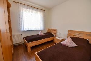 ein Schlafzimmer mit zwei Betten und einem Fenster in der Unterkunft Haus "Luv und Lee" Appartement LEE02 in Döse + 16 Fotos