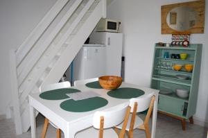 a kitchen with a table with chairs and a staircase at Triplex avec jardinet - wifi - à 400m de la plage in Courseulles-sur-Mer