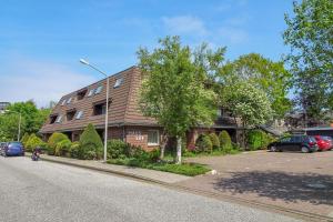 a building on a street with cars parked in a parking lot at Haus "Luv und Lee" Appartement LEE06 in Döse