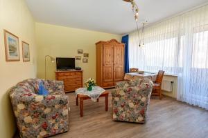 ein Wohnzimmer mit zwei Stühlen und einem Tisch in der Unterkunft Haus "Luv und Lee" Appartement LEE17 in Döse