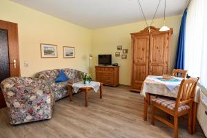 ein Wohnzimmer mit einer Couch und einem Tisch in der Unterkunft Haus "Luv und Lee" Appartement LEE17 in Döse