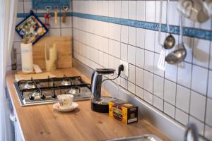 巴勒莫Scirocco House的厨房柜台配有带茶壶的炉灶 更多37张照片