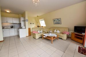 ein Wohnzimmer mit zwei Sofas und einem Tisch in der Unterkunft Haus "Luv und Lee" Appartement LUV23 in Döse