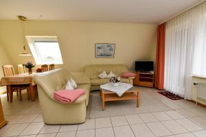 ein Wohnzimmer mit einer Couch und einem Tisch in der Unterkunft Haus "Luv und Lee" Appartement LUV23 in Döse