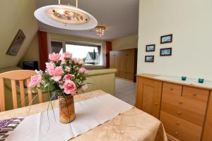 eine Vase rosafarbener Blumen auf einem Tisch in der Unterkunft Haus "Luv und Lee" Appartement LUV23 in Döse