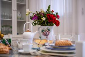 巴勒莫Scirocco House的花瓶,食物盘的桌子