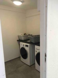 a laundry room with a washer and a washing machine at WIFI - PARKING - SUPERBE T3 SPACIEUX ET MODERNE!!!! in Saint-Denis