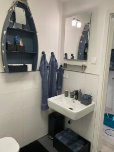 La salle de bains est pourvue d'un lavabo et d'un miroir. dans l'établissement Pier 67 Neustadt, à Neustadt in Holstein