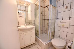 a bathroom with a shower and a toilet and a sink at Haus "Najade" Appartement NAJA8 in Döse +9 photos
