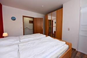 a bedroom with a large white bed in it at Haus "Nautilus" Appartement NAU08 in Duhnen