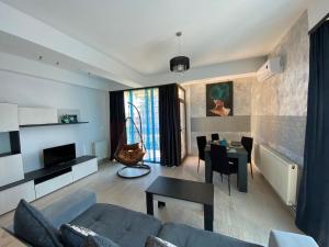 a living room with a couch and a table at Apartament Ella T2 in Mamaia Sat/Năvodari