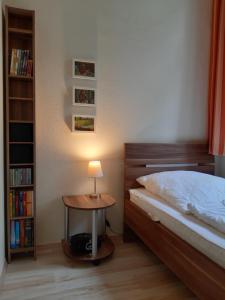 ein Schlafzimmer mit einem Bett und einem Tisch mit einer Lampe in der Unterkunft Ferienwohnung Villa im Park in Wangerooge