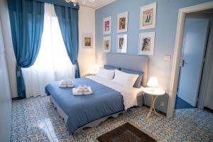 Un dormitorio con una cama azul con toallas. en Scirocco House, en Palermo