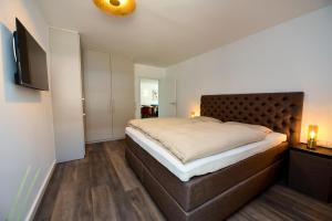 a bedroom with a large bed and a flat screen tv at Haus "Panorama" Appartement PAN022 in Duhnen +25 photos