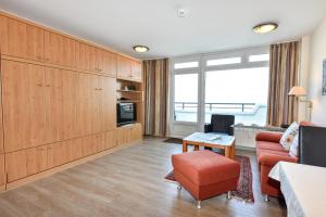 a living room with a couch and a chair at Haus "Panorama" Appartement PAN027 in Duhnen
