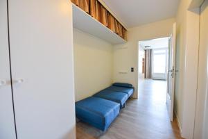a room with two blue beds in a hallway at Haus "Panorama" Appartement PAN027 in Duhnen +17 photos