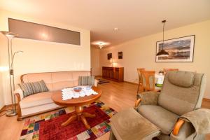 a living room with a couch and a table at Haus "Panorama" Appartement PAN049 in Duhnen