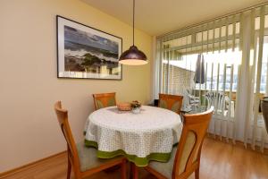ein Esszimmer mit einem Tisch, Stühlen und einem Fenster in der Unterkunft Haus "Panorama" Appartement PAN049 in Duhnen