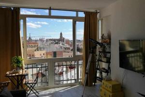 マラガにあるEl Balcón de Malagaの市街の景色を望む大きな窓が備わる客室です。