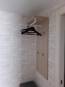 a room with a white brick wall with a closet at Chusovskaya Hotel in Zavod Chusovskoye