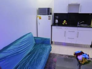a living room with a blue couch and a kitchen at The view studio in Hurghada