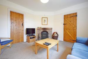 un soggiorno con divano, tavolo e camino di Vane Cottage - Lewes a Lewes