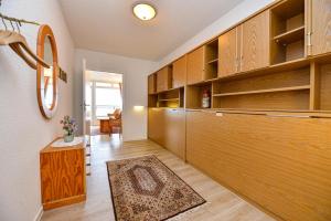 a kitchen with wooden cabinets and a rug on the floor at Haus "Panorama" Appartement PAN096 in Duhnen