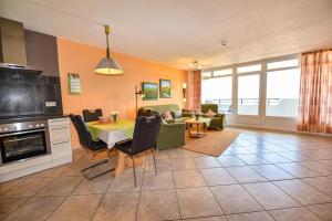 a kitchen and living room with a table and a couch at Haus "Panorama" Appartement PAN102 in Duhnen