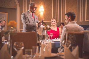 a man is pouring a bottle of wine at a table at Corick House Hotel & Spa in Clogher